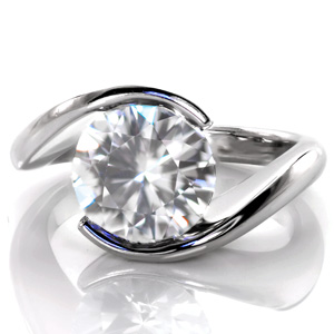 Our Ripple design is shown here with a 2.50 carat round cut center stone. This modern design features a delicate, high polished band that wraps around the solitaire gem to form the center setting. The luster of the metal band for this half bezel design adds a beautiful compliment to the sparkle of the center stone.