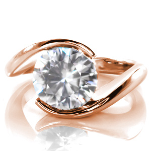 Our Ripple design is shown here with a 2.50 carat round cut center stone. This modern design features a delicate, high polished band that wraps around the solitaire gem to form the center setting. The luster of the metal band for this half bezel design adds a beautiful compliment to the sparkle of the center stone.