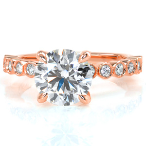 Custom combinations of ring elements result in amazing settings! This modern design features individual bezel set diamonds creating the upper half of the band. The center diamond is held in an elegant four prong setting that stands out against the milgrain edged bezels of the band.