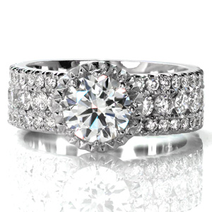 Design 3618 is a beautiful wide band designed with three rows of diamonds. The raised center stone is held in an eight-prong setting. Faceted metal creates a sparkling border around the center stone to mimic a halo. The faux-halo is upraised to allow for a straight wedding band to be worn next to the ring. 