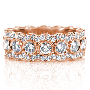 Design 3629 is a lavish eternity span diamond band. The mixed setting styles and varied stone sizes create a  pattern of overlapping halos around larger bezel set interior gems. The scalloped diamond rails that form the partial halos are held in U-cut style prong settings.