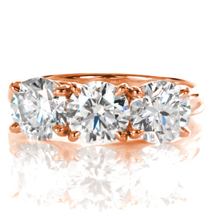 This breath-taking three stone ring features three individual 1.00 carat round brilliant cut diamonds. The high polished band is a little wider to accent the sparkle of the stones with the luster of the high polished metal. A woven, trellis style setting forms a decorative basket on the sides of the piece.