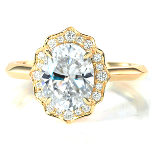Shown with a 2.00 carat oval cut diamond, this majestic engagement ring features a scalloped halo set with mixed sizes of round brilliant cut diamonds. The knife edge band blends with the subtle points of the halo and adds to the vintage appeal of the design. 