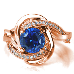 Evoking thoughts of the rippling ocean waves, Design 3651 features intertwining bands that flow around the blue sapphire center stone to form a unique halo. The contrast between the diamond set band and the high polished band adds to the motion of the piece. 
