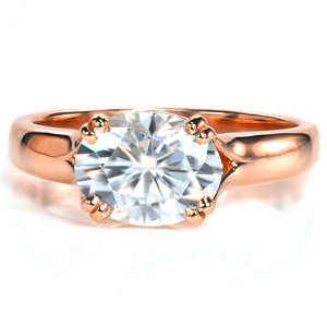 This contemporary solitaire setting exudes modern elegance. The gentle split shank of this design perfectly frames the East-West set oval diamond. A flared band flows to meet the trellis design from the sides of the center setting to form pairs of double prongs. 