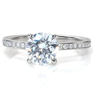 Divine is a timeless diamond engagement ring style. This elegant band features narrow, high polished rails to either side of the side diamonds. The crown flows out of the band to form a secure claw prong setting around the center stone, while sitting up high enough to easily fit with a wedding band. 