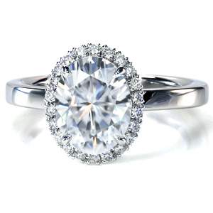 This classic diamond engagement ring design features a delicate halo made up of hand-created U-cut pavé settings. The single width, high polished band offers a contrast to the sparkle of the halo and center stone. This beautiful ring was designed to allow easy pairing with a variety of wedding band styles.