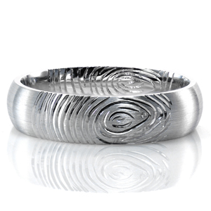 Adding the fingerprint of your future spouse to the design of your wedding band is a beautiful way to keep a piece of them with you wherever you go. This custom domed band is shown with a comfort fit interior. The brushed finish on the outside of the band offers contrast to the lines of the print.