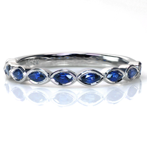 For a stunning take on a gemstone band, consider using uniquely shaped stones to create a geometric pattern. These marquise cut blue sapphires add a beautifully rich details in the form of the color and the scalloped shape created by setting them East-West. 