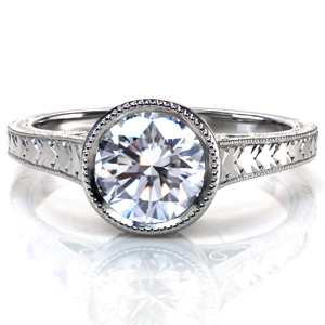 Design 3682 is shown with a round brilliant cut center stone. Milgrain is applied to the bezel setting, then it continues onto the tapered band. Bright cut hand engraving is applied to the top and the sides of the band, and the ring is finished with hand wrought filigree curls. 