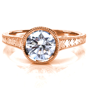 Design 3682 is shown with a round brilliant cut center stone. Milgrain is applied to the bezel setting, then it continues onto the tapered band. Bright cut hand engraving is applied to the top and the sides of the band, and the ring is finished with hand wrought filigree curls. 