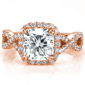 Shown with a 2.0 carat cushion cut center stone, Design 3692 features a unique micro pavétwisted split shank design. Hand formed u-cuts minimize the metal holding the stones while securely fashioning the stones, giving this ring maximum sparkle. A diamond halo around the center stone completes this stunning ring.