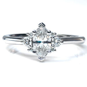 Design 3694 is shown with a 0.70 marquise center stone in a simple yet elegant setting. A cluster of three stones accents each side of the marquise, and the stones all rest in a cathedral setting. The highly polished band draws the eye to the brilliant, sparkling center. 
