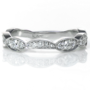 Contoured to perfectly cradle your engagement ring, Valerian features a beautifully scalloped design. The beaded milgrain texture along the edges of the band creates a cohesive whole with the beadset round diamonds. High polished sides show off the beautiful luster of the metal.