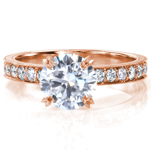 A timeless design with subtle details, Design 3719 delivers a lot of sparkle. A four prong crown is fashioned high to place all the attention on the impressive 1.50 carat round center stone, and the band is set with  micro pavé stones. Milgrain detail is applied by hand to the band and the prongs.  