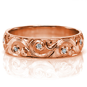 Design 3742 features an intricate, high polished, swirling design that perfectly contrasts a matte textured background. Sparkling diamonds are bezel set within the swirls. The polished rails are accented with milgrain detail, completing this elegant band. 