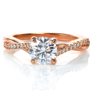 Design 3745 features a 0.70 carat diamond in a classic four prong setting. Tucked under the setting is an infinity symbol. Completing this ring is a delicately intertwined  cathedral style band, weaving one strand of high polished metal with one that has diamonds set by hand in an intricate, French pave style.
