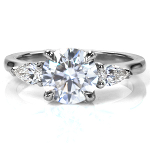 A stunning 1.7 carat round brilliant diamond sits elegantly atop Design 3748. The classic four prong setting is flanked with large, pear shaped stones, leading into the high polished band. The band tapers slightly into the setting, drawing the eye into the diamonds. 