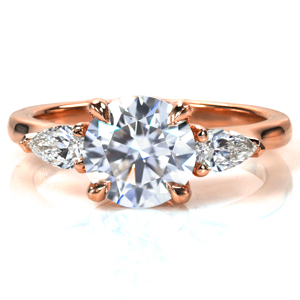 A stunning 1.7 carat round brilliant diamond sits elegantly atop Design 3748. The classic four prong setting is flanked with large, pear shaped stones, leading into the high polished band. The band tapers slightly into the setting, drawing the eye into the diamonds. 