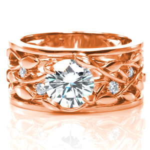 A dazzling 1.20 carat diamond is nestled in unique, petal shaped prongs. The intertwining leaf and vine design of the band is accented with round brilliant diamonds, sparkling between the vines. This wide band is finished with thin rails on each side of the ring and a high polish shine. 