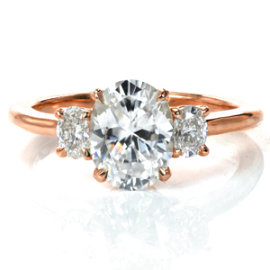 Our Charlotte design is a classic three stone engagement ring with a modern update. A 1.5 carat oval diamond is flanked by oval diamonds on each side creating a perfectly symmetric look. The simple basket setting provides a clean look, and the high polish of the band complements the brilliant diamonds beautifully.