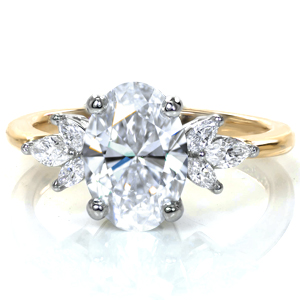 A 2.0 carat oval is flanked by clusters of floral-inspired marquise diamonds on each side. The rich luster of the gold band contrasts beautifully with the platinum crown, adding warmth to the design while allowing the diamonds to stand out and sparkle. 
