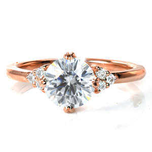 Graceful details make all the difference in our Ariel design. A 1.20 carat diamond is held by four sets of double prongs in a compass setting. A delicate draped basket adorns the center diamond, and a thin, polished band with clusters of side diamonds completes this understated design. 