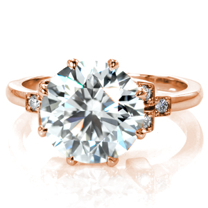 An impressive 4.20 carat diamond is held securely in an eight prong basket setting. The straight lines of the prongs are perfectly complemented by the geometric feel of the accents on each side of the center setting. Round diamonds are set in square shapes leading into a simple, polished band. 