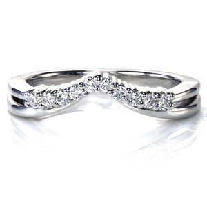 Designed to look like two bands coming together at an apex, this custom diamond band is the perfect complement to any engagement ring. Round brilliant diamonds are set in tiny bead prongs atop the band. The graceful curve of this band adds a touch of elegance and sparkle to your wedding set. 