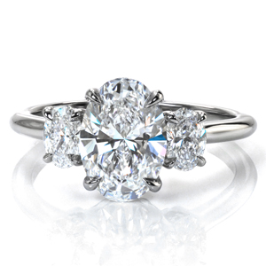 Design 3801 is a classic three stone engagement ring with a modern update. A 1.7 carat oval diamond is flanked by oval diamonds on each side, creating a beautifully symmetric look. The basket setting is decorated with sparkling diamonds, and the high polish of the band complements the brilliant diamonds beautifully. 