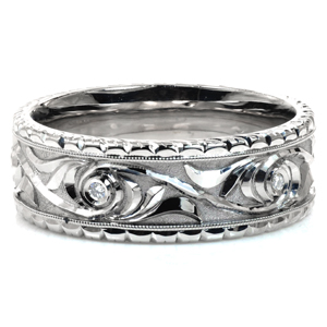 Design 3802 is a beautiful contrast in textures. The ornate, raised floral design is bright cut by our jeweler for added shine and detail. The background is stippled by hand to further accentuate the design. The rails of the ring are also hand engraved, and milgrain texture borders the intricate designs. 