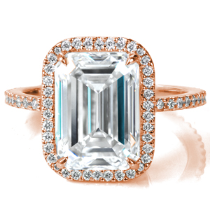 A stunning 4.5 carat emerald cut diamond is set in four claw prongs and framed by a delicate, hand set halo. The unique, decorative basket is also studded with diamonds in an intriguing swirled pattern. More diamonds are hand set on the thin band for added sparkle from every angle. 