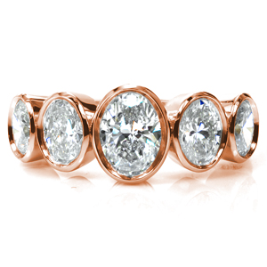 A modern update on the classic five stone band, this design showcases five oval diamonds graduating in size toward the center. The diamonds, totaling two carats, are securely set in low, polished bezels for a clean, streamlined look. This design is perfectly proportioned to cover your finger in sparkle!