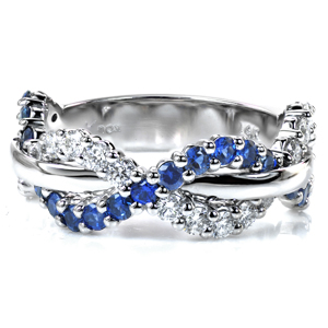 Intertwining rows of glittering diamonds and rich blue sapphires weave around a high polished center row of metal in this intriguing design. Each stone is hand set in small, bead-shaped shared prongs, providing a beautiful and secure setting and adding a lovely texture to the ring. 