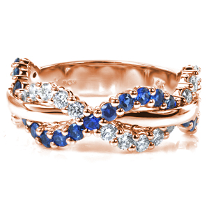 Intertwining rows of glittering diamonds and rich blue sapphires weave around a high polished center row of metal in this intriguing design. Each stone is hand set in small, bead-shaped shared prongs, providing a beautiful and secure setting and adding a lovely texture to the ring. 