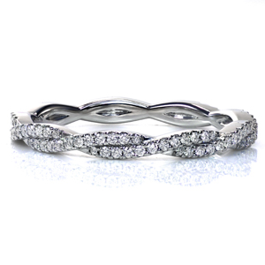 An updated twist on a classic diamond band, this design combines sparkle and style. Glimmering hand-set diamonds adorn the elegantly intertwined band. Beautiful worn alongside a variety of engagement ring styles, as part of a stack, or on its own, this design shimmers from every angle!
