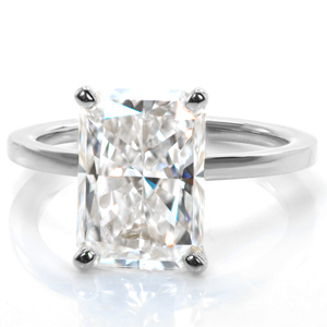 A stunning four carat radiant cut diamond is perched atop a polished band in this regal design. A draped basket is adorned with diamonds to add sparkle from every angle, and elegantly curved prongs are perfectly shaped and placed on the cut corners of the stone. 