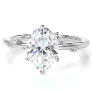 Simple and understated, this elegant engagement ring is sure to charm. A unique six prong setting cradles a 1.20 carat oval. A few small, scattered diamonds adorn the rounded, polished band for that extra touch of sparkle. The final touch is a crescent shape set with diamonds that climbs up the curved prongs. 