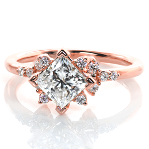This lovely engagement ring features a kite set princess cut diamond nestled in between clusters of shimmering rounds. More prong set diamonds protrude from the basket setting, adding another layer of sparkle. A narrow band with a mirror-like finish completes this design. 