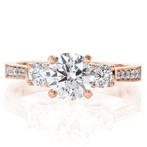With a vintage inspired tapered band and contemporary three stone setting, the Always design is a timeless statement. A stunning 1.00 carat round brilliant cut diamond is accented by two lower-set round cut side diamonds. The tapered band is finished with micro pavé and a fine milgrain edge.