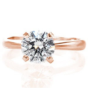 The Classic Solitaire design proudly displays a 1.00 carat round brilliant diamond within the four prong crown. The band is gently raised towards the top creating a cathedral style setting. The delicate width of the 14k white gold band is finished in a high polish for radiance and shine. 