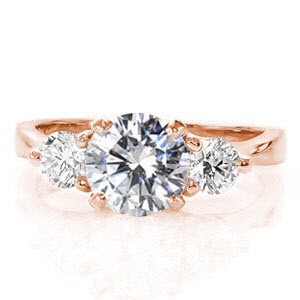The Contour Trellis is a timeless three stone design with an elegant profile revealing a woven setting. The 1.00 carat round brilliant cut diamond center stone is embellished with two 0.25 carat diamonds nestled on both sides. Crafted in 14k white gold, the band glistens with a high polish.