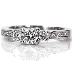 Round Royal Three Stone is a classic design with a stylish modern flair. The bead-set diamonds along the band add a contemporary spin to the time-honored style of a three stone ring. The 0.50 carat center stone is flanked by a round brilliant diamond on each side of the band for a timeless appeal.