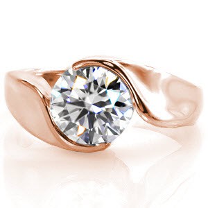This perfectly balanced Yin-Yang setting embraces a 1.50 carat round brilliant cut diamond in a wrap bezel setting. The beautiful curved bezel melds into the shank for a minimal and classic look. The band tapers down in size and is finished with a high polish luster.