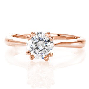 Inspiration is truly a vision with its 1.00 carat round brilliant diamond. The double prongs add a sophisticated touch to this timeless center stone. The smooth polished metal of the 14k white gold heightens the luster of the band. Bezel set peek-a-boo diamonds embellish each side of the ring for a decorative accent. 
