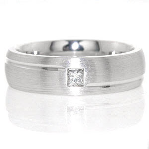 The New York design is a contemporary band with a distinctive bypass channel wrapping around the ring. The high polished groove adds interest and further emphasizes the sophisticated look of the 0.15 carat princess cut diamond flush set in the center. 