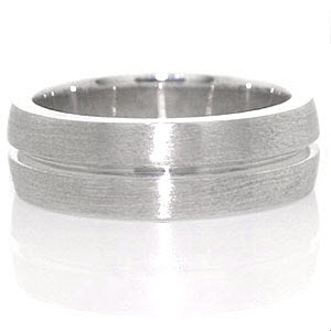 The Jersey band is a prominent design crafted in 14k white gold. The wide presence of the band slightly domes for a well suited fit. A single channel is forged down the band center. The brushed finish to the surface highlights the eternity channel stripe.