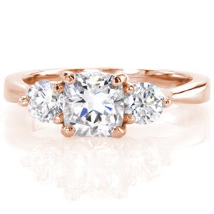 The Cushion Contour Trellis is a timeless three stone design with an elegant profile revealing a woven setting. The 0.75 carat cushion cut center diamond is embellished with two 0.21 carat diamonds nestled on each side. Crafted in 14k white gold, the band glistens with a high polish.
