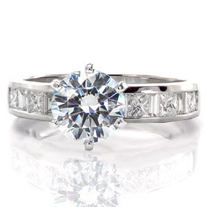 Autumn is a chic design with the bright white luster of the 14k white gold metal and diamonds. The center features a 1.00 carat round brilliant set in a symmetrical six prong crown. The alternating brilliant and step cuts of the princess and baguette stones create a dramatic affect along the band.